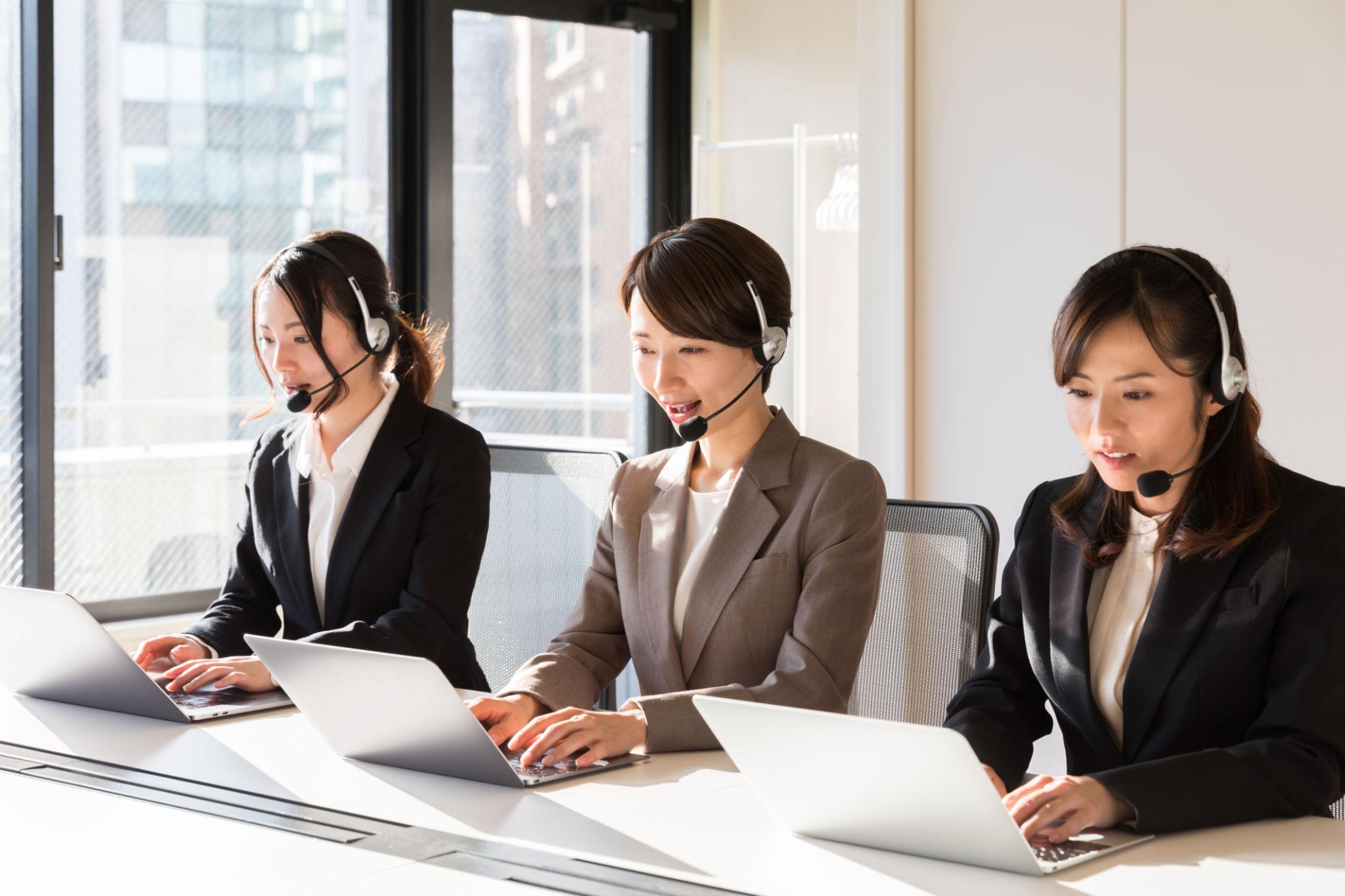 複数の担当者がノートPCで同時に対応している様子
